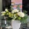 This luxurious modern arrangement features clusters of white Roses, set against dramatic