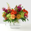A vibrant celebration of color, this bold arrangement blends sunny yellows, fiery