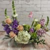 This arrangement has pastel color flowers with Easter Eggs and butterfly, including