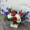 Cabana Flower arrangement features hot pink roses, blue delphinium and white hydrangeas.