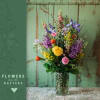 Colorful mixed blooms arranged in a tall vase. This one will make