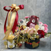 A stunning floral box accompanied by a fragrant candle and gourmet chocolates