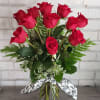 12 gorgeous premium roses are creatively arranged in a clear glass vase