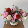 An elegant flower arrangement of premium red and pink blooms nestled in