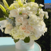 A peaceful arrangement featuring white lilies, hydrangeas, carnations and roses &mdash; designed