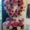 Floral arrangement with a wooden base decorated with roses and carnations in