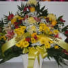 A mixture of yellow daisies, yellow roses, yellow fuji mums, red alstromaria