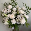 An elegant all-white arrangement featuring roses, lilies, carnations, and alstroemeria, accented with