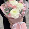 Small bouquet made with white chrysanthemums, pink roses, and small carnations, wrapped
