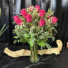 1 dozen hot pink roses in a glass vase with premium greens