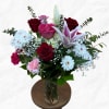 Assortment of red, pink and white florals in a traditional glass vase.