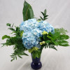 A beautifully arranged vase filled with Blue Hydrangeas and mixed greens (vase
