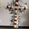 A beautiful cross arrangement of white roses, red carnations, and soft lavender
