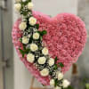 A heartfelt pink heart arrangement crafted with soft carnations and accented by
