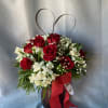  Red roses arranged with white accent flowers.