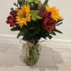 cheerful and vibrant floral arrangement featuring bright sunflowers, elegant red alstroemeria, fresh