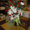 A mixture of white lilies, red roses, bells of Ireland, dendro orchids