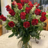 The perfect vase with red roses and greens for your loved one