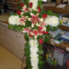 A cross with a mixture of fuji mums, red roses, stargazers, curly