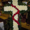 A cross with a mixture of  roses, fuji mums,  and