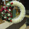 An open wreath with a mixture of white fuji mums, red roses