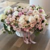 Luxury blush and ivory rose basket arrangement featuring hydrangeas, spray roses, and