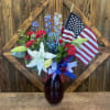 Red, white, and blue arrangement in a vase that is red, white