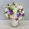 This is a stunning floral arrangement featuring delicate white roses, lush lisianthus