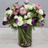 The arrangement features spray rose, ranunculus, and tulips for a sweet look.