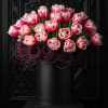 A collection of pink tulips in a black vase with purple lavender