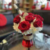 Red roses and white hydrangea in a red vase.