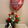 The sweetest pooch surrounded by flowers and a balloon