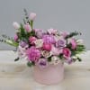 This hatbox is filled with lavender and blush roses, tulips, and fragrant