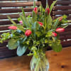 ten fresh spring tulips in a vase with  greens