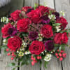 Red roses, accented with scabiosa, berries &amp; beautiful greens, with leaf wrapped