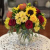 With roses and daises, this arrangement encapsulates the seasons best colors!