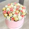 This arrangement features a round pink gift box filled with white and