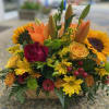 A lively arrangement with roses, sunflowers, lilies and more. Perfect for the