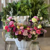 A colorful mix of pink and hot pink Roses, Ranunculus, Dianthus, Waxflower