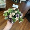 A mini silk arrangement in purples and mixed pinks designed in a