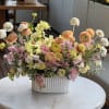 This bright and cheerful ceramic vase arrangement features stunning blooms such as
