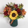 A teal glass vase filled with warm pretty colors. A sunflower as
