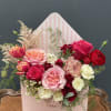 This charming arrangement comes in a pink envelope style box and features