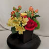 Deep red roses glow beside bursts of orange and golden yellow blooms