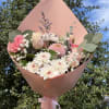 Handheld bouquet with a mix of soft pink blooms.
Wrap color may differ.