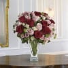 The lush bouquet includes red roses, pink roses, white spray roses and