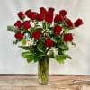 Two dozen long stem red roses traditionally designed in a vase. 
If