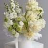 A soft, sculptural design in creamy whites and fresh greens. Layered roses