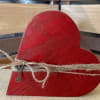 This charming wooden heart is wrapped in rustic twine and finished with