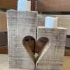 This two-piece wooden candle set features offset sizes with a heart when